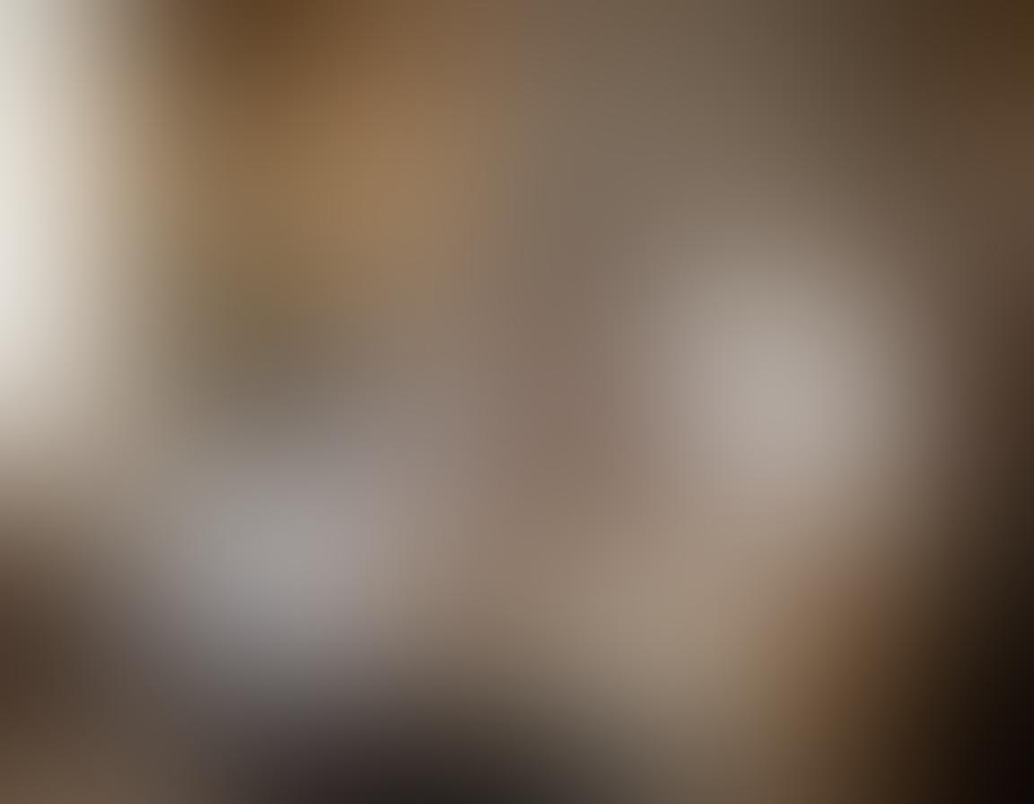 A romantic scene featuring a beautifully arranged display of intimate apparel, including lace bras and silk panties, elegantly draped over a vintage vanity. Soft lighting accentuates the delicate fabrics, alongside accessories like pearl jewelry and a fragrant candle. The background hints at a luxurious bedroom setting with plush pillows and tasteful decor. The image evokes a sense of allure and elegance. super-realistic. warm tones. soft focus.